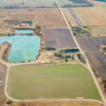 Aerial View of Rural Landscape with Pond and Scattered Buildings