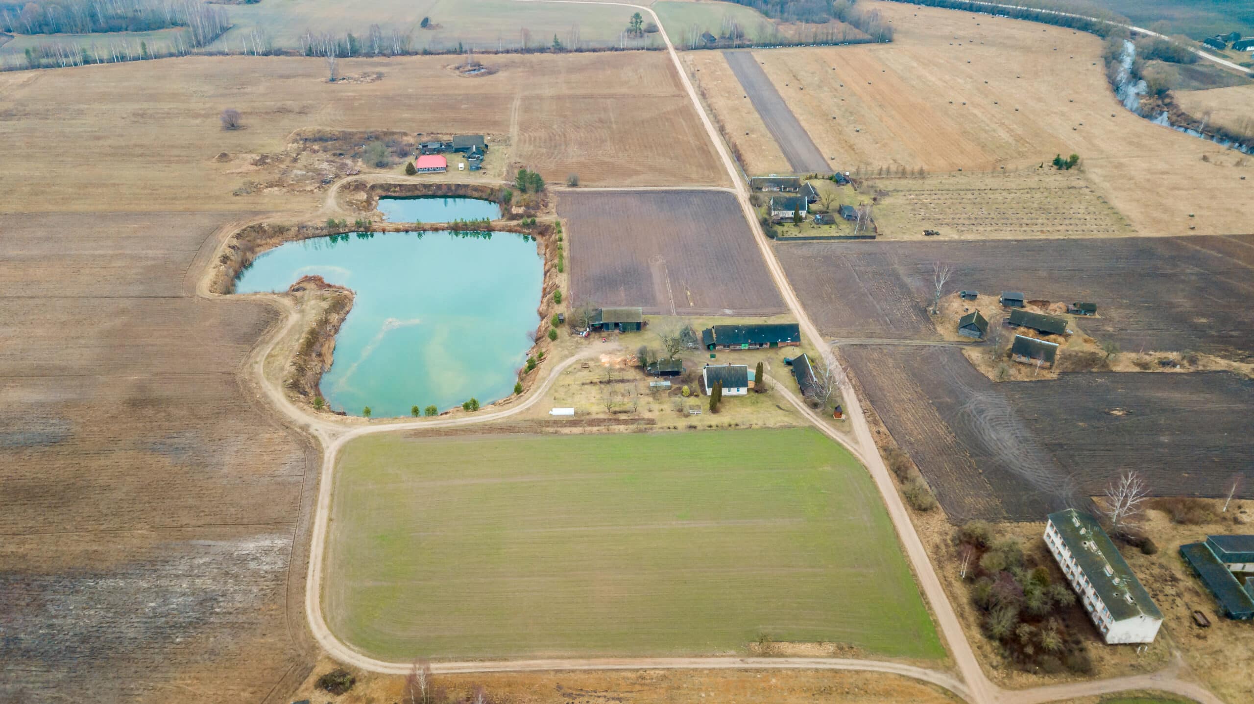 Aerial View of Rural Landscape with Pond and Scattered Buildings