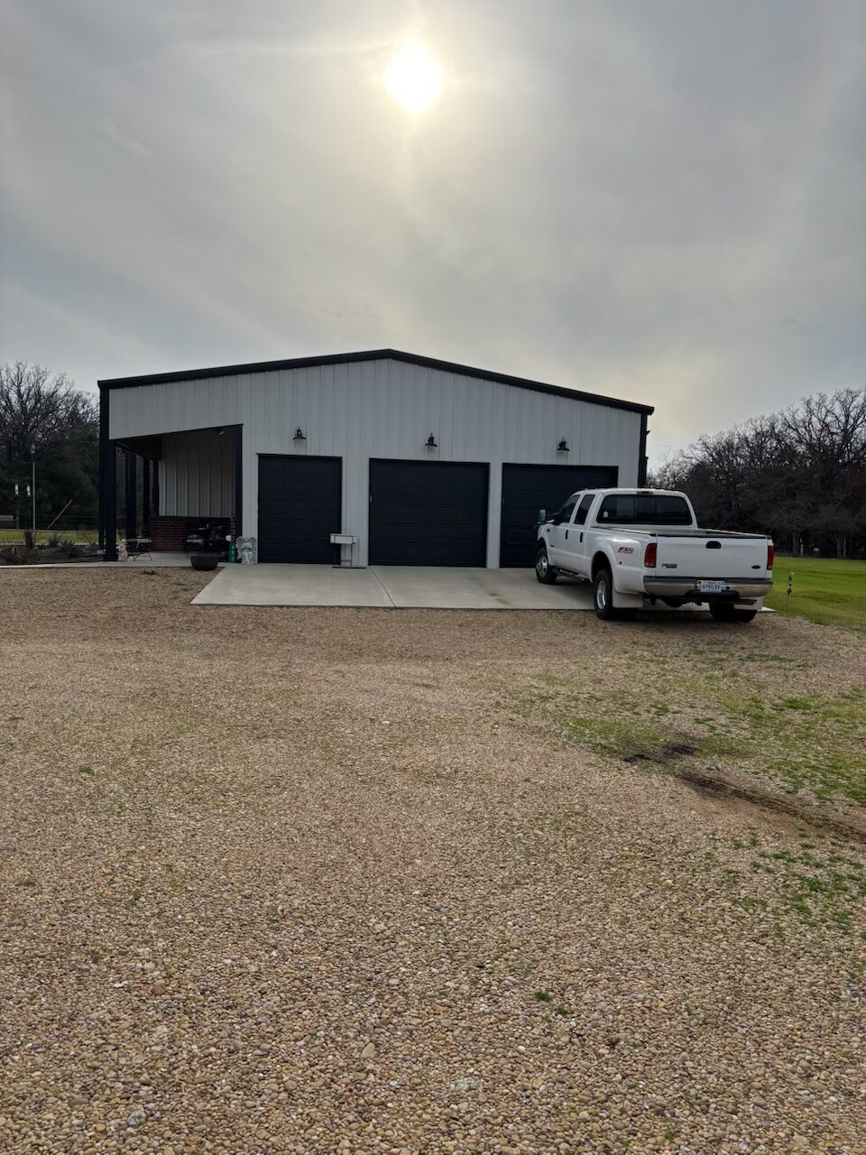 white and black barndo and metal garages build next to it