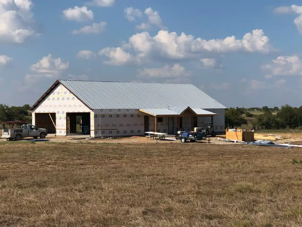 Barndominium built around Knoxville in Tennessee with light grey roof and white walls.
