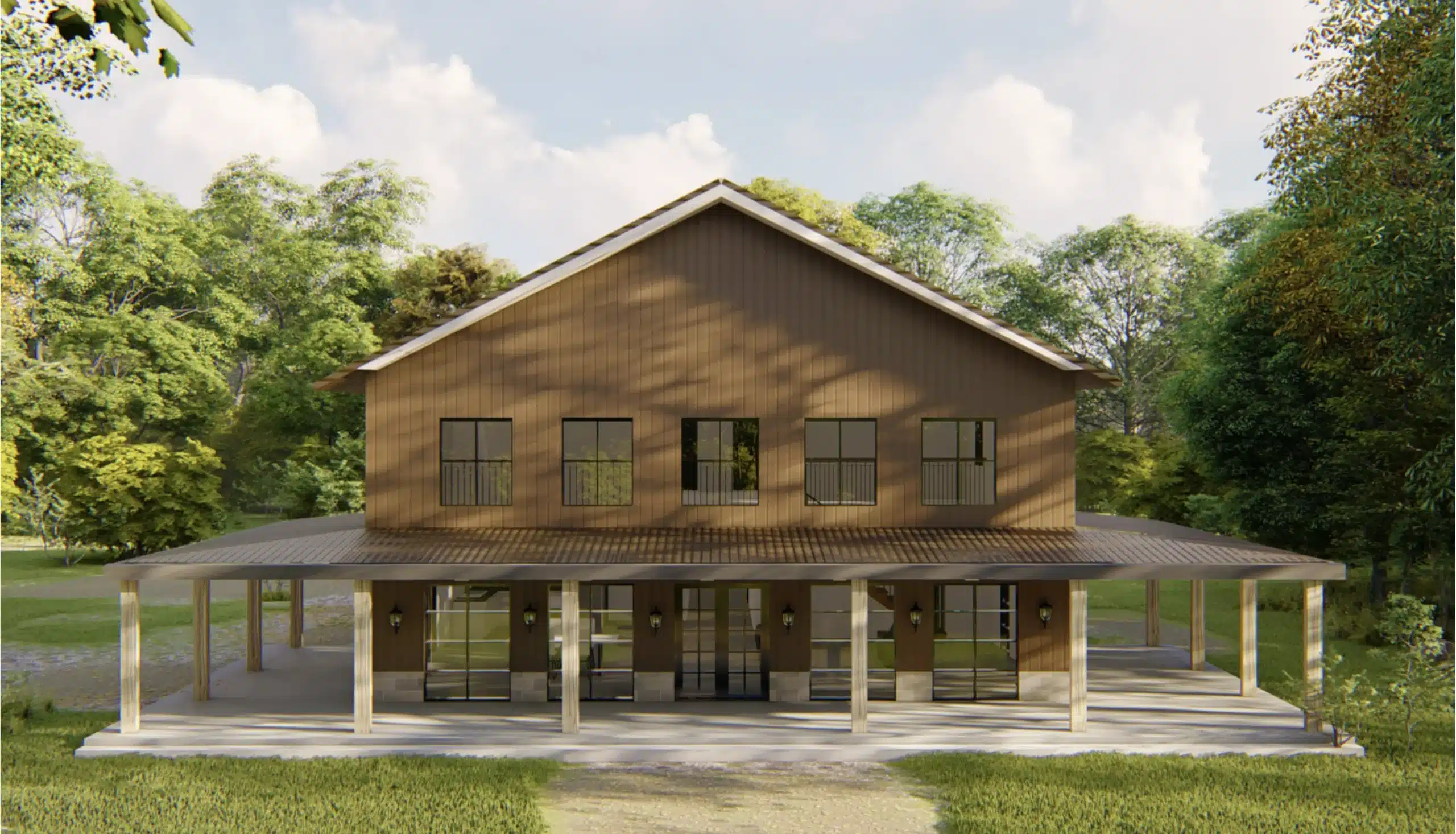 Front view of a large two-story brown barndominium with wraparound covered porch, metal roof, and wooded surroundings in a peaceful rural setting.
