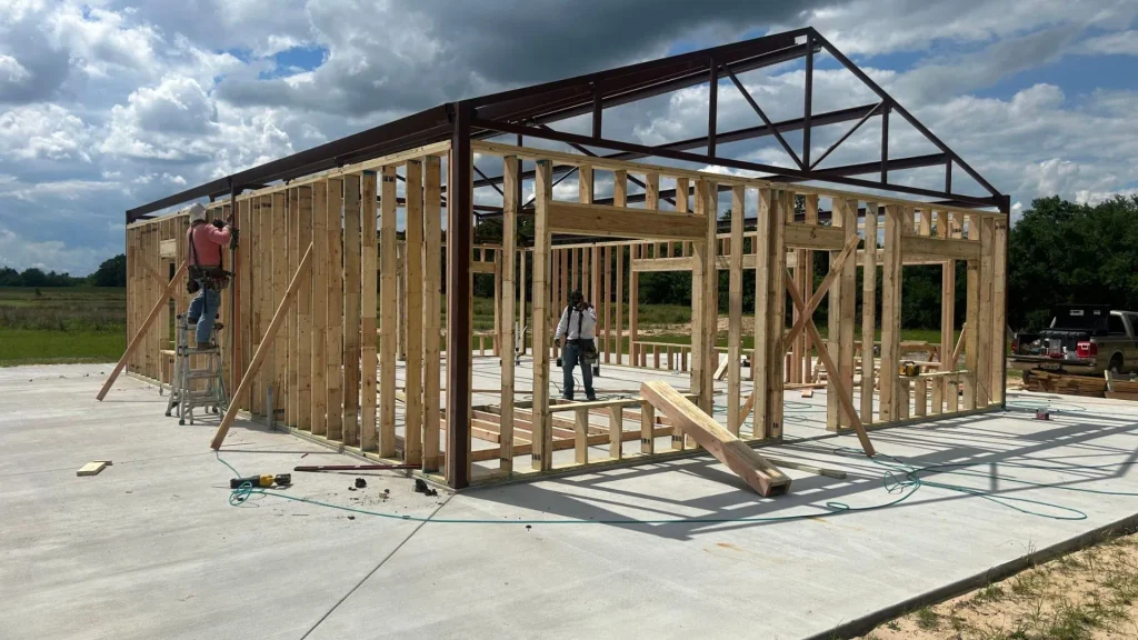 Tennessee barndominium framing under construction with steel roof structure and timber wall framing