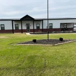 ready built barndominium with white wallsa nd metal dark brown roof in a rural area in Tennessee